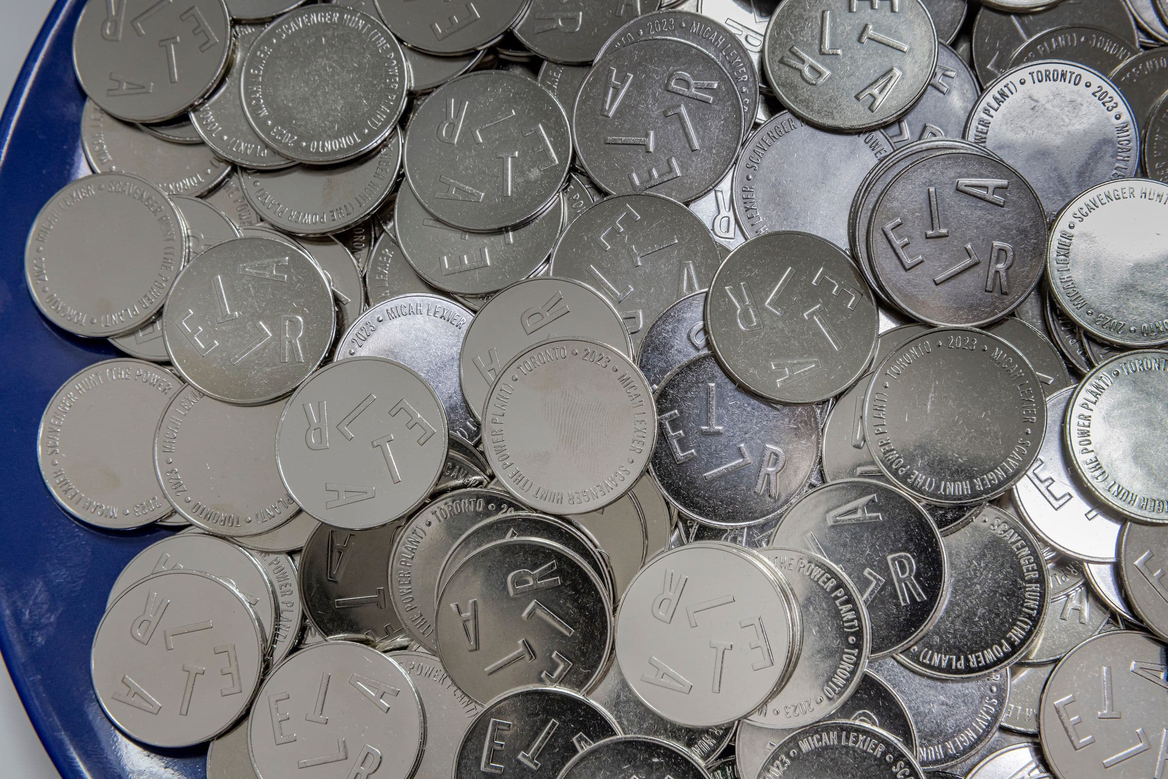 Micah Lexier, Scavenger Hunt (The Power Plant) (detail), 2023. Five metal letters, map, statement, custom-minted coins. Courtesy the artist and Birch Contemporary, Toronto. Installation view: in parallel, The Power Plant, 2023. Photo: Toni Hafkenscheid.