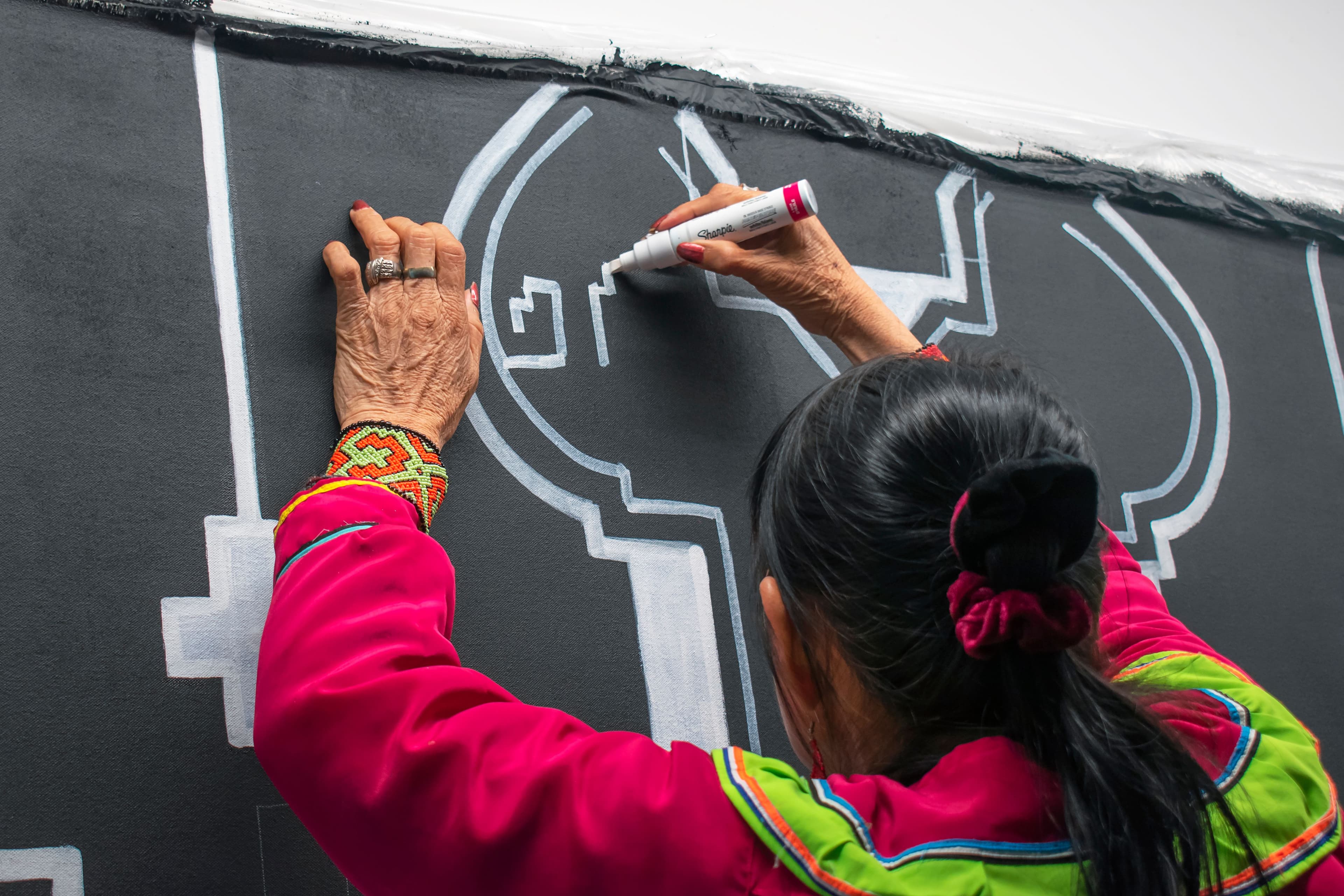 Olinda Reshinjabe Silvano working on a kené mural at OCAD University. Photo by Hyerim Han